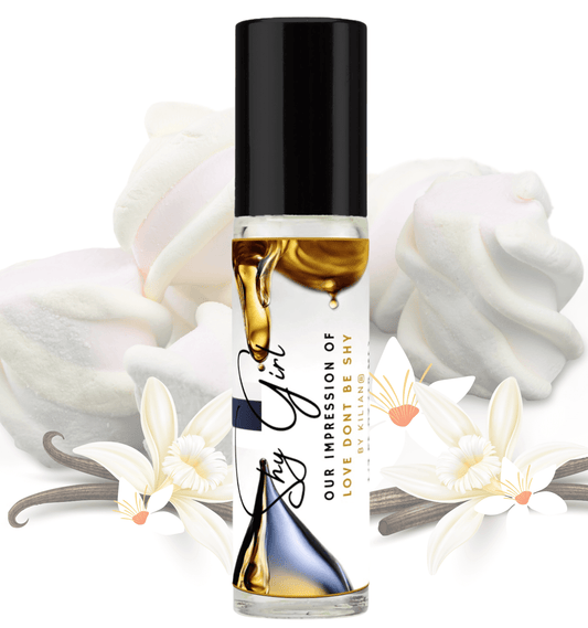 HauteBlends Shy Girl pure perfume oil concentrate inspired by Love, Don't Be Shy — 10ml travel-size clear glass rollerball bottle with a sleek black cap, styled against an artistic background of orange blossom, honeysuckle, and warm marshmallow notes.